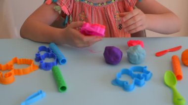 Renkli kil. Çocuk elleri renkli kille oynuyor. Plastiksin. Hamur oyna.