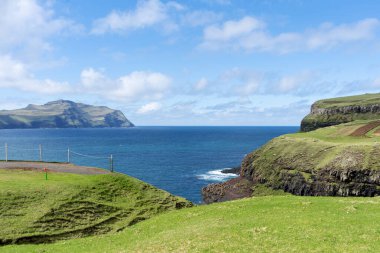 Risin ve Kellingin harika. Deniz koyunda, güzel dağların arasında ve mavi gökyüzünde güzel bulutların arasında. Streymoy adasındaki Tijornuvik körfezi. Faroe Adaları. Danimarka. Avrupa. Manzaralar. Doğa.