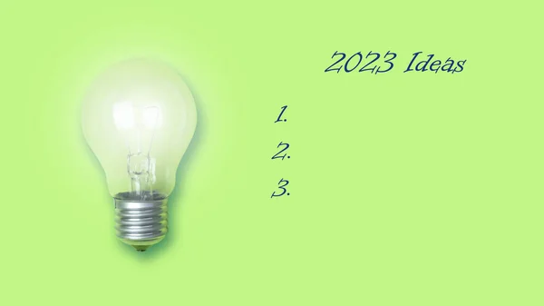 Koncepce Nových Nápadů Pro Rok2023 Žhnoucí Žárovka Jasně Zeleném Pozadí — Stock fotografie