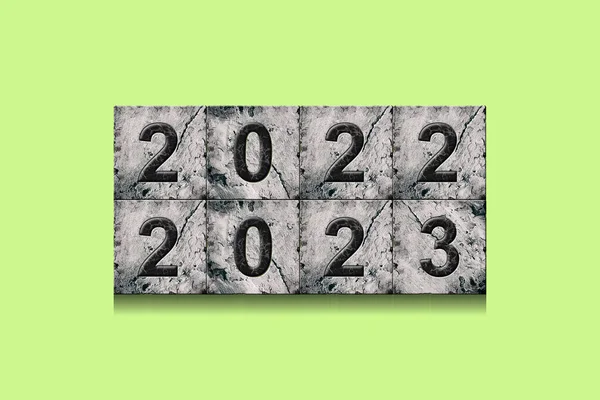 2022, 2023, numbers on stone blocks, on a bright green background. New Year concept. Festive background.