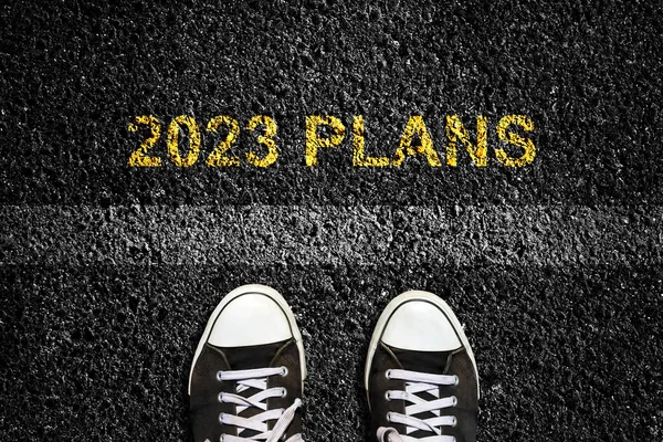 2023年 平面图 在沥青路面上 和运动鞋前面的车道标记 顶部视图 即将到来的新年的概念 新的计划和想法 生活方式 图库图片