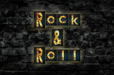 Rock 'n Roll. Paslı demir harflerden yapılmış kelimeler, eski, eski tuğlalardan yapılmış duvarlar. Müzikte yön. Müzikal stil. Tasarım ögesi.