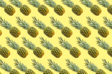 Sarı arka planda bir sürü ananas var. Tam ananas. Tropik meyveler. Meyveler. Arkaplan.