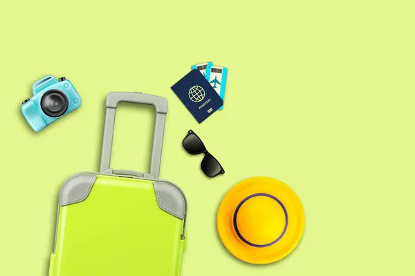 Travel concept. Green travel suitcase, sunglasses, camera, hat and passport with tickets on yellow background. Copy space. Travel background.
