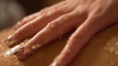 Masör, kaplıca salonundaki genç bir kıza terapi amaçlı ayak masajı yapıyor.