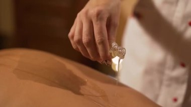 Masör, kaplıca salonundaki genç bir kıza terapi amaçlı ayak masajı yapıyor.