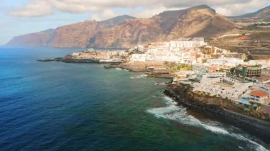 Harika bir manzara. Dalgalar kayalara çarpıyor. Kanarya Adaları. Tenerife. Los Gigantes. Kapatın. Hava aracı görüntüsü. Puerto de Santiago kasabası. Volkanik plaj. Kimse..