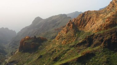 Okyanusa giden Masca Vadisi 'ndeki bir dağın eteğindeki küçük rahat yerleşim yerinin muhteşem hava manzarası. Mesafe kayalıkları, dik kayalıklar. Ünlü turistik köy. Vadi, yürüyüş alanı. Tenerife Kanaryası