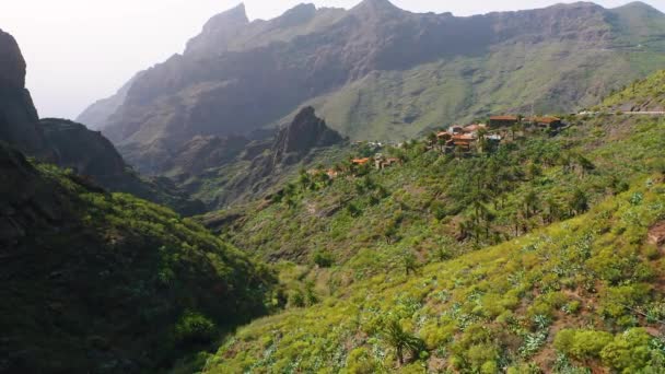 在马斯卡峡谷的一座山上 一个舒适的小居民点通向海洋的壮观的空中景观 山脉悬崖陡峭的峭壁著名的旅游村 远足区 Tenerife金丝雀 — 图库视频影像