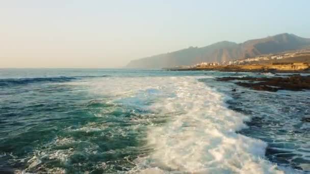 暴风雨天气里 无人机在海面上低空飞行 海浪发泡飞溅 落基海岸背景是Los Gigantes悬崖Tenerife 碧绿的大西洋水域风景秀丽 金丝雀 — 图库视频影像