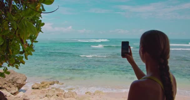 年轻女子用智能手机拍海景的慢镜头 度假及休闲概念 绿碗泳滩 — 图库视频影像