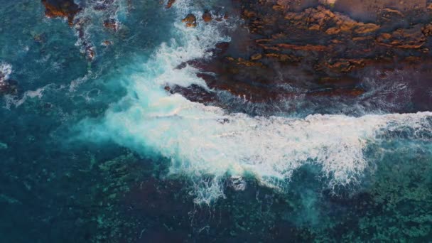 强烈的海浪在大西洋浅水中冲撞 汹涌的水流在黑色的火山灰沙滩上旋转着 溅起水花 迷人的无人机视图 — 图库视频影像