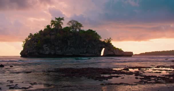 山の島の上に美しい夕日クリスタルベイビーチヌサペニダ海の波に沿って歩いて水着で孤独な女性の背面ビューにあります 水面に反射したオレンジ色の光 穏やかな海 — ストック動画