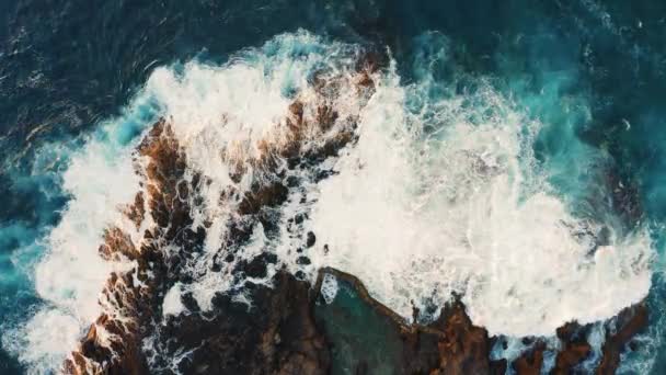 Azureの海の波は 水しぶきと白い泡で岩の多い海岸火山の形成でクラッシュします 空中飛行を停止する — ストック動画