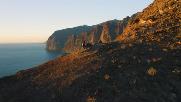 Manusia Dengan Ransel Memanjat Sisi Gunung Dan Merenungkan Lanskap Laut — Stok Video