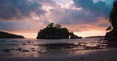 Bali Adası Endonezya 'daki Crystal Bay Sahili' nde koyu bulutlu bir gökyüzü. Gün batımında okyanusun sığ sularında kayalık bir siluet. Sakinlik tatili kavramını gevşet.
