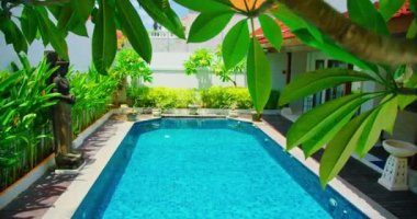 Yeşillik ve bahçe tasarımlı mavi yüzme havuzu. Endonezya Bali adası. Rahatlama, lüks tatil, tatil. El bilgisayarı görüntüleri.