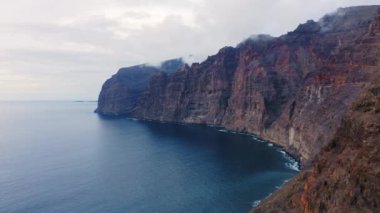 Büyük kayalıklar ve derin mavi okyanus üzerinde uçan Los Gigantes Tenerife. Sakin deniz ve Atlantik sularının muhteşem manzarası. Cennet Kanarya Adası 'na bir gezi. Yolculuk. Volkanik deniz manzarası