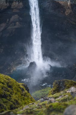 Güney İzlanda 'daki Haifoss şelalesine yakın. Su dipteki kayalara çarpıyor ve etrafa sıçrıyor. Odaklanmamış önplan.