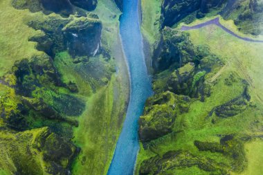 İzlanda 'da yağmurlu bir günde ünlü ve eşsiz Fjadrargljufur Vadisi' nin havadan görünüşü. Yosunlu kayalıklar ve dağ nehri. Seyahat turizmi.