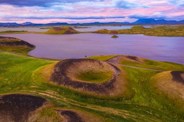 Myvatn, İzlanda 'nın destansı günbatımında havadan panoramik görüntüsü. Yeşil Düzlüklerdeki Volkanik Kraterler Bulutları ve gökyüzünü birbirine bağlar.