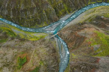 Süt mavisi bir nehrin yukarıdan görünüşü ve İzlanda 'da yürüyüş yolu..