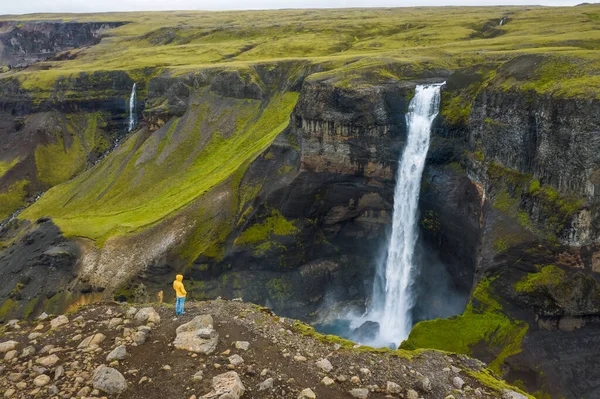 人们站在悬崖边欣赏冰岛高山谷地和海佛斯瀑布的空中景象 — 图库照片