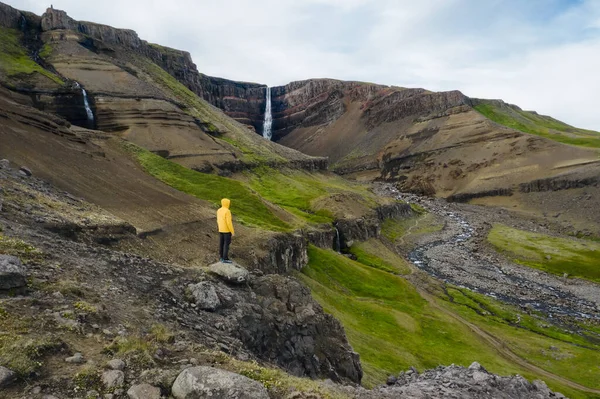 アイスランドでヘンギフォスの滝を楽しむ黄色のコートの男の空中ビュー — ストック写真
