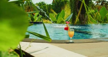 Relax view of welcome drink by the pool. Luxury vacation in modern resort tourist spot. Glass of orange juice. Refreshment and enjoyment tropical view. Bali Island Nusa Penida Indonesia.