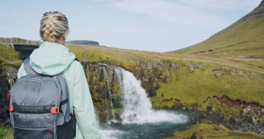 Kirkjufellsfoss Watterfall ve Kirkjufell 'in önündeki kadın Kuzey İzlanda' da.