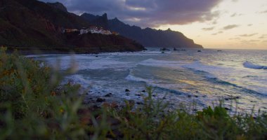 Beautiful golden sunset at the north of tenerife, Atlantic Ocean, Almaciga black sandy beach. Twilight.