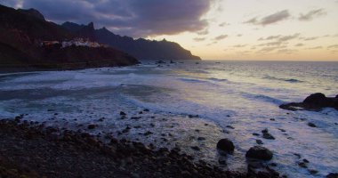 Beautiful golden sunset at the north of tenerife, Atlantic Ocean, Almaciga black sandy beach. Twilight.