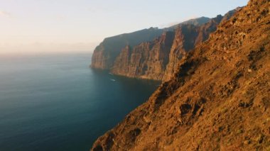 Sunset in mountains Los Gigantes Cliffs with deep ocean view Tenerife island, Canary, Spain. The Giants in Atlantic waters. Cinematic aerial static drone point of view. Nobody.