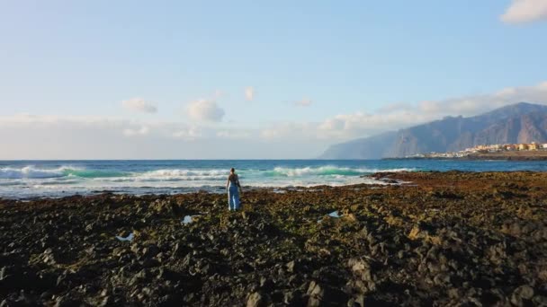 Traveler Explores Rocky Beach Wide Foaming Waves Huge Cliffs Background — Video