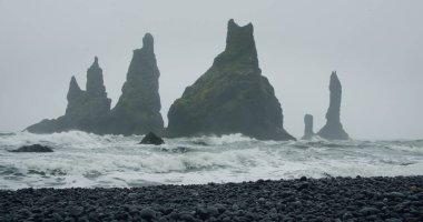Siyah kumsaldaki kayalıklar ve dalgalar, Vik, İzlanda 'daki Reynisfjara.