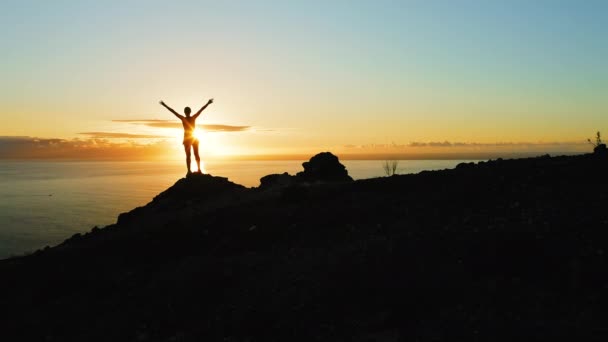 Молодая Вдохновленная Женщина Поднимает Руки Стоя Вершине Горы Над Морем — стоковое видео