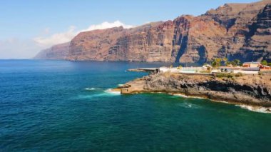 Atlantic Ocean Los Gigantes, Tenerife, Spain. Tourist resort beach. Volcanic shoreline. Blue sea waves splash.