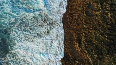 Pristine rocky volcanic barren coastline and turquoise ocean water with white foaming waves. Aerial top down static drone view. Tenerife Canary Islands. Nobody.