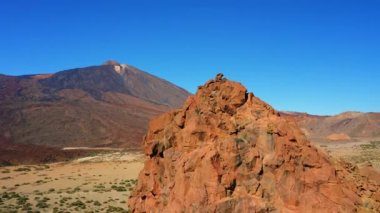 Aerial view of unique rock formation with the mountain Teide volcano summit in the background. Deserted volcanic landscape. Barren valley. Tenerife Spain.