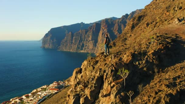 Чоловік Стоїть Вершині Гірської Скелі Фоні Кам Янистого Пляжу Блакитного — стокове відео