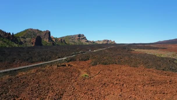 テイド国立公園 テネリフェ島のシュールな火山砂漠を横断する車の運転の空中ビュー 背景に黒い砂利不毛の風景や山々 目的地 — ストック動画