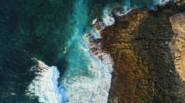 Pristine rocky volcanic barren coastline and turquoise ocean water with white foaming waves. Aerial top down static drone view. Tenerife Canary Islands. Nobody.