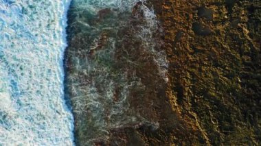 Pristine rocky volcanic barren coastline and turquoise ocean water with white foaming waves. Aerial top down static drone view. Tenerife Canary Islands. Nobody.