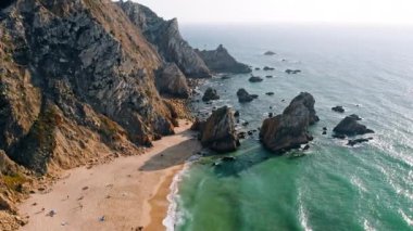 4K Aerial drone footage of the beautiful Praia da Ursa beach in Sintra, Portugal in Sunset golden hour light