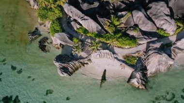 Anse Source d 'Argent plajının güneşli gün ışığında havadan çekilmiş görüntüleri. Dalgalar çekildiğinde sığ bir göl. La Digue Adası, Seyşeller