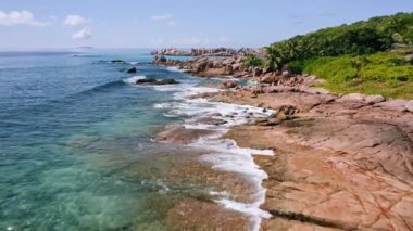 Seyşeller, La Digue Adası 'ndaki tropikal kıyı şeridinde granit kayalar ve okyanus kıyıya doğru akıyor. Yaz tatili kavramı
