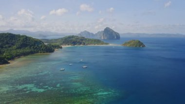 El Nido 'nun mavi göl manzarası ve turist botları. Palawan adasında ünlü bir turistik yer. Mavi körfezli deniz burnu ve yukarıdan görünen tekneler. Yaz ve seyahat tatili