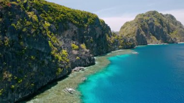 Matinloc Adası, El Nido, Palawan, Filipinler. Resimli deniz kıyısının havadan görünüşü, kristal berrak su, keskin kayalıklar ve mercan resifleri.