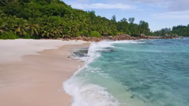 Seyşeller 'deki Mahe adasındaki tropikal kumlu plajın 4K hava aracı görüntüleri.