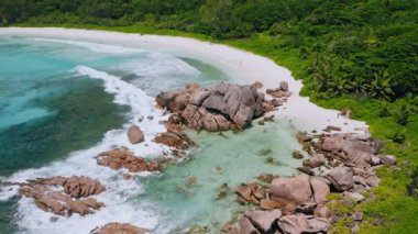 Tropikal sahil Anse Coco 'nun insansız hava aracı görüntüleri. Mavi göl ve yağmur ormanı gibi bir cennet. Seyşeller 'deki La Digue Adası